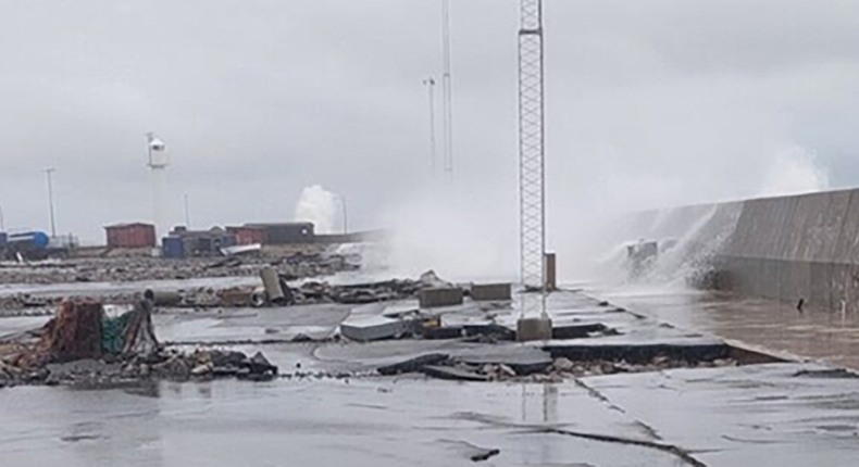 Kraftiga vågor slår över kanten på hamnen i Simrishamn. Beläggningen är trasig och stenar uppspolade.